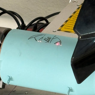 Teal tumbler that is being engraved 