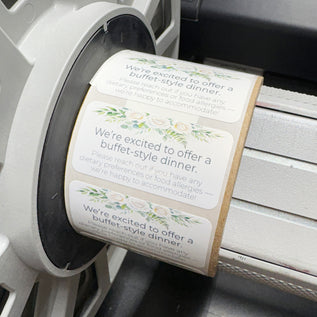 Roll of buffet-style dinner announcement labels on a printer.
