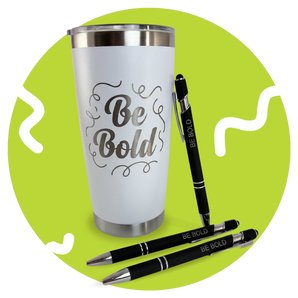 White tumbler with 'Be Bold' text and three black pens on a green background