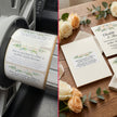 Roll of printed buffet-style dinner invitations with a printer and flowers on a wooden surface.