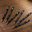 Set of pens with Aether Solutions branding on a wooden surface