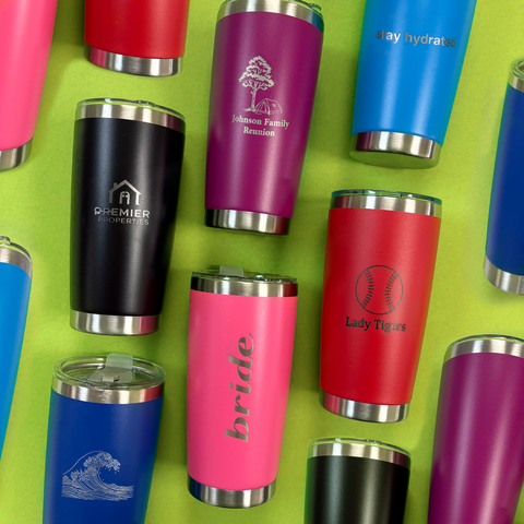 Collection of personalized engraved tumblers on a green background